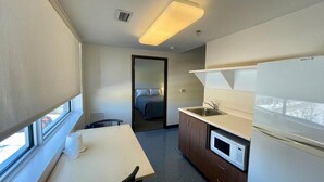 A compact kitchen with a microwave, sink, and a window overlooking a snowy landscape. - Résidence Saint-Paul - Quiet, practical living in Ottawa (Ottawa)