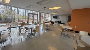 A spacious cafeteria with high ceilings, large windows, and a mix of tables and chairs. - Résidence Saint-Paul - Quiet, practical living in Ottawa (Ottawa)