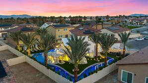 A residential area with houses, a swimming pool, and palm trees. - Isle of Palms: Sleeps 27, Lazy River & Waterslide (Indio)