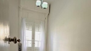 A room with a bed, a wooden nightstand, a door with a keycard, and a window with curtains. - Hotel Costamar Miramar (Miramar)