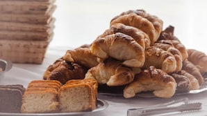 A stack of croissants and sliced bread on a table. - Hotel Costamar Miramar (Miramar)
