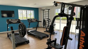A gym with treadmills, a weight bench, and exercise equipment. - Apto. 2 quartos Vista Rio Negro P. Negra (Manaus)