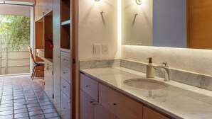 Une salle de bain moderne avec un lavabo en marbre, des meubles en bois et un grand miroir.