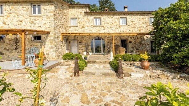 A stone building with a covered patio, a small garden, and a door leading to the entrance. - Juniper Apartment - Relax, Nature and Panorama with Private Pool (Toscana)