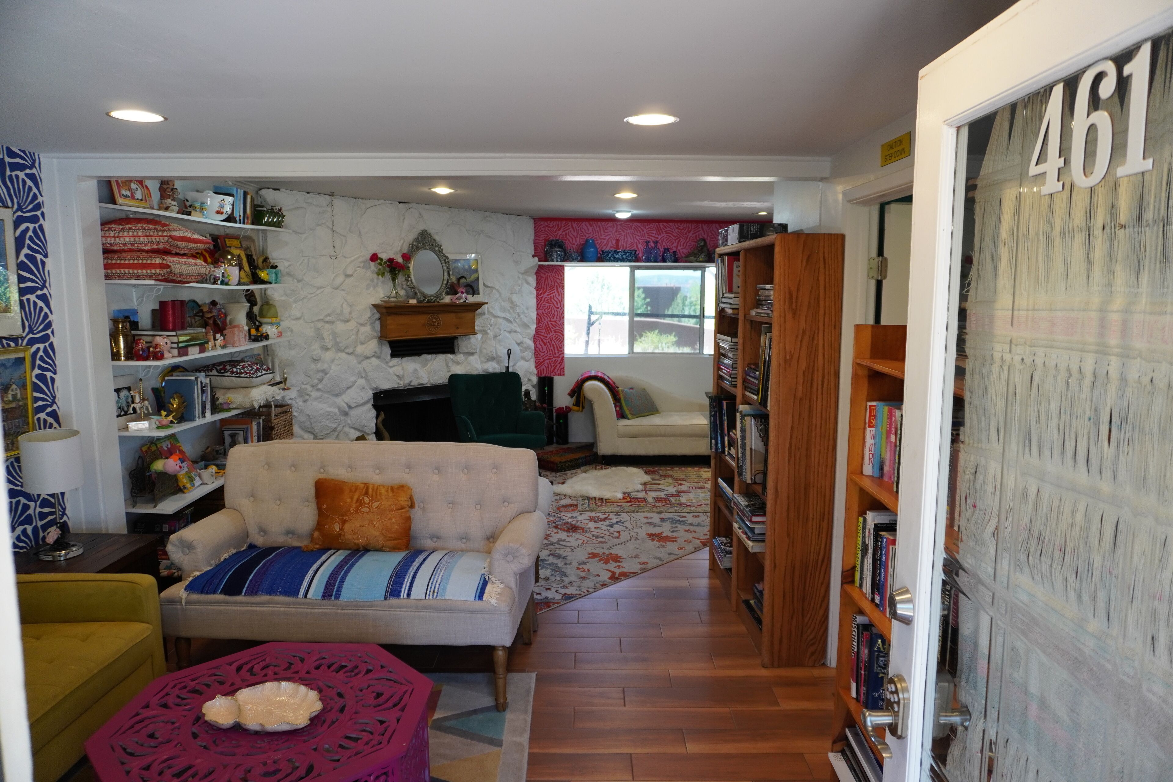 A cozy living room with a sofa, a coffee table, and a bookshelf.