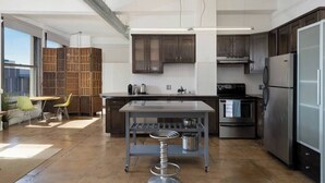 Una cucina moderna con isola centrale, elettrodomestici in acciaio inossidabile e vista sulla città.