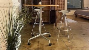 Una stanza con un'ampia finestra, una pianta in vaso e una parete divisoria con scaffali.