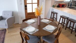 A dining area with a round table set for four, surrounded by wooden chairs. - Parkside Central Retreat (Houston)