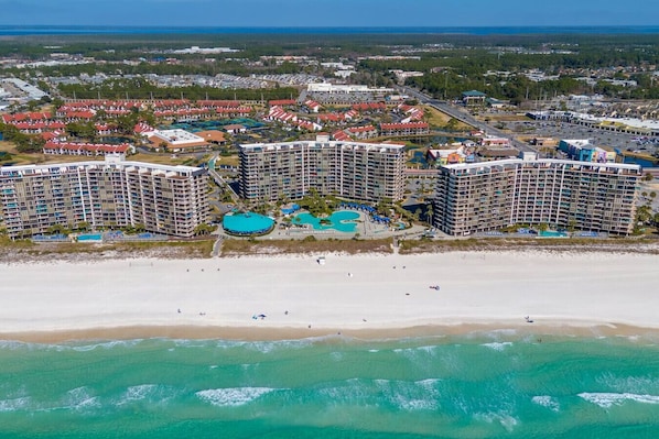 Ein Küstenhotel mit mehreren Hochhäusern, einer Strandlage und einem großen Poolkomplex.