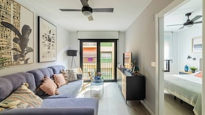 A modern living room with a sofa, a side table, and a ceiling fan. - Modern apartment 3rd floor with shared heated swimming pool (Alicante/Alacant)