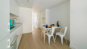 A modern kitchen with white cabinets, a teal microwave, and a wooden floor. - Ap. Marino 2nd floor shared heated swimming pool (Alicante/Alacant)