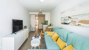 A modern living room with a TV, sofa, and artwork. - Costa 3rd floor shared heated swimming pool (Alicante/Alacant)