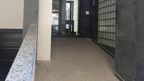 A hallway with a marble floor, a dark glass door, and a number '17' sign on the wall. - Ap.Marino 3rd floor shared heated swimming pool (Alicante/Alacant)