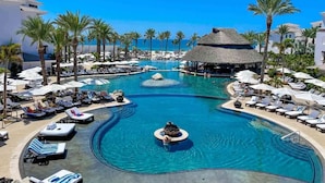 A resort with multiple swimming pools, palm trees, and beach umbrellas. - Cabo Azul Hilton Vacation Club 2 Bedroom Ocean View (San José del Cabo)