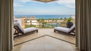 A balcony with two sunbeds, a view of the sea, and a pool. - Cabo Azul Hilton Vacation Club 2 Bedroom Ocean View (San José del Cabo)