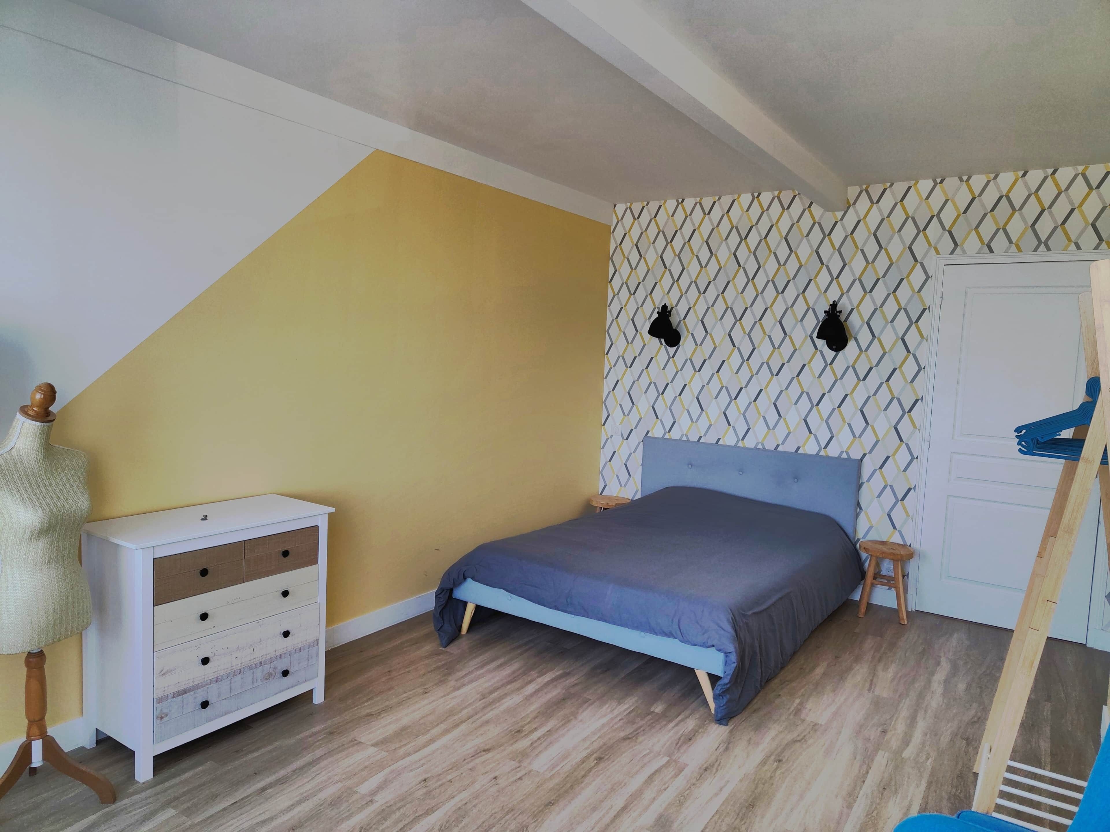 Ein Schlafzimmer mit Bett, Kommode und Kleiderschrank.