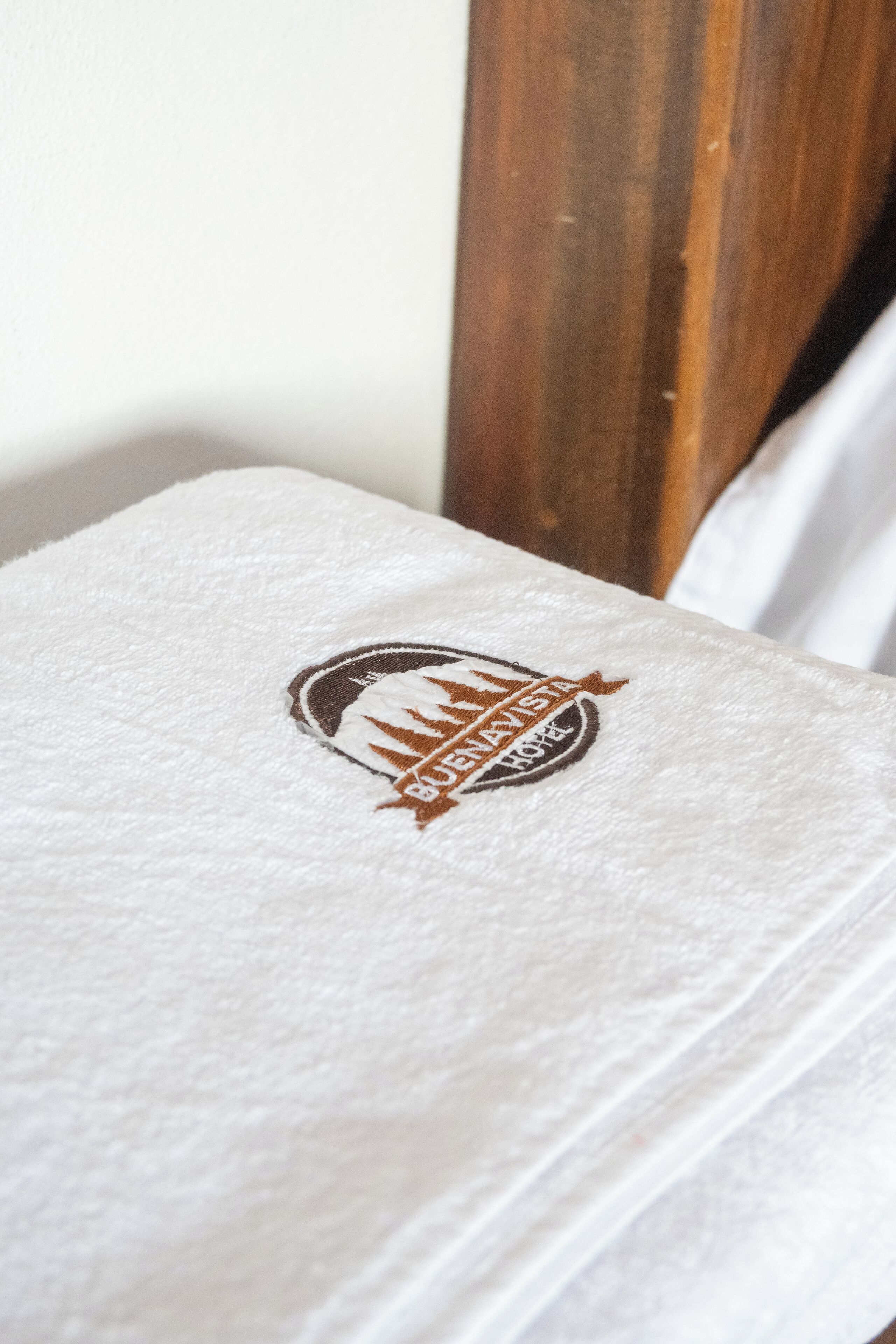 A white towel with a logo and text indicating a hotel name and location.