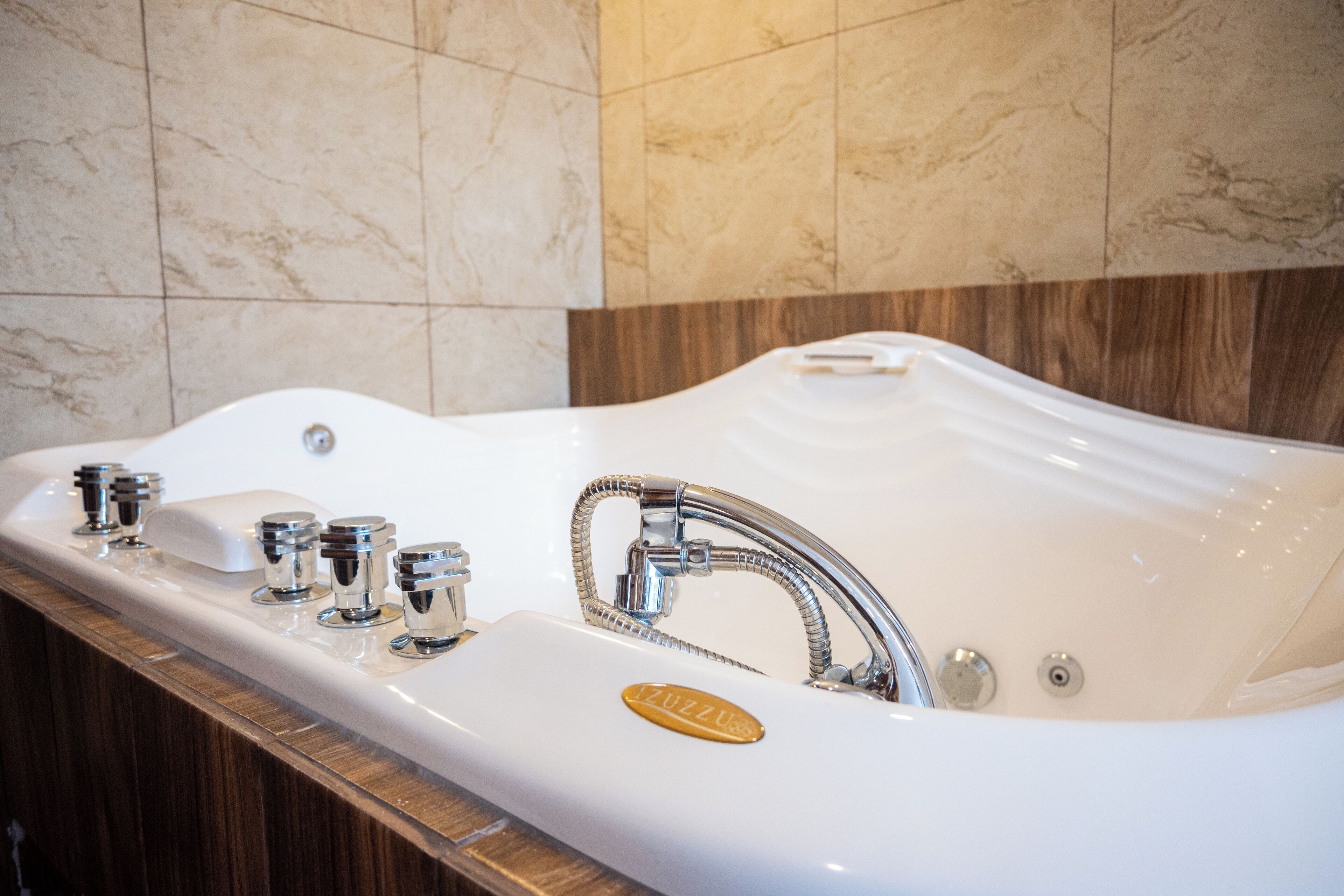 A modern bathroom with a freestanding bathtub, chrome fixtures, and a marble wall.