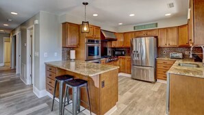 Una cocina moderna con armarios de madera, electrodomésticos de acero inoxidable y encimera de granito.