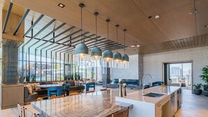 Una cucina moderna con una grande isola, elettrodomestici integrati e un angolo salotto con vista sulla città.