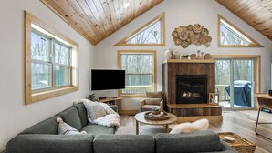 Un loft espacioso con techos altos, ventanas grandes, una chimenea y un rincón de estar acogedor.
