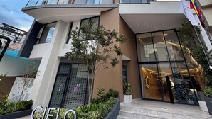 A modern high-rise building with multiple balconies and a prominent entrance. - Deluxe green suite/ La Carolina (Quito)