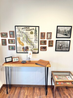Ein Zimmer mit einer Karte des Giants Highway, einem Holztisch mit einem Laptop, gerahmten Bildern und einem kleinen Tisch mit einer Glasplatte.