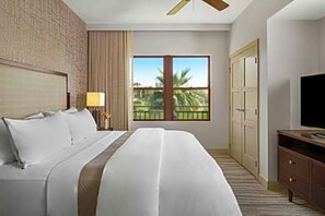 A hotel room with a large bed, a TV, a wardrobe, and a window with a view of palm trees. - Coachella Valley 2 Bdr Villa (sleeps 8 adults) Westin Desert Willow, Palm Desert (Palm Desert)