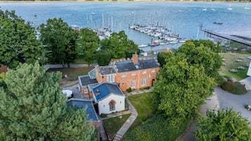 A coastal property with a marina, a brick building, and surrounding greenery.