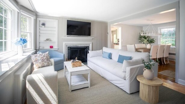 A modern living room with a fireplace, white sofas, and a television. - Family Cottage with 4 King Beds  (Norwalk)