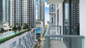 Ein Hochhaus mit Pool und Grünflächen an der Seite, moderne Architektur und ein klarer Himmel.