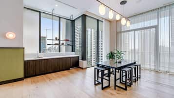 Une cuisine moderne dotée d’une grande fenêtre, d’un plancher en bois et d’un coin repas avec une table et des chaises.