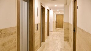 A hotel corridor with wooden doors and a tiled floor. - Mi Zona Lodging Chapultepec (Mexico City)