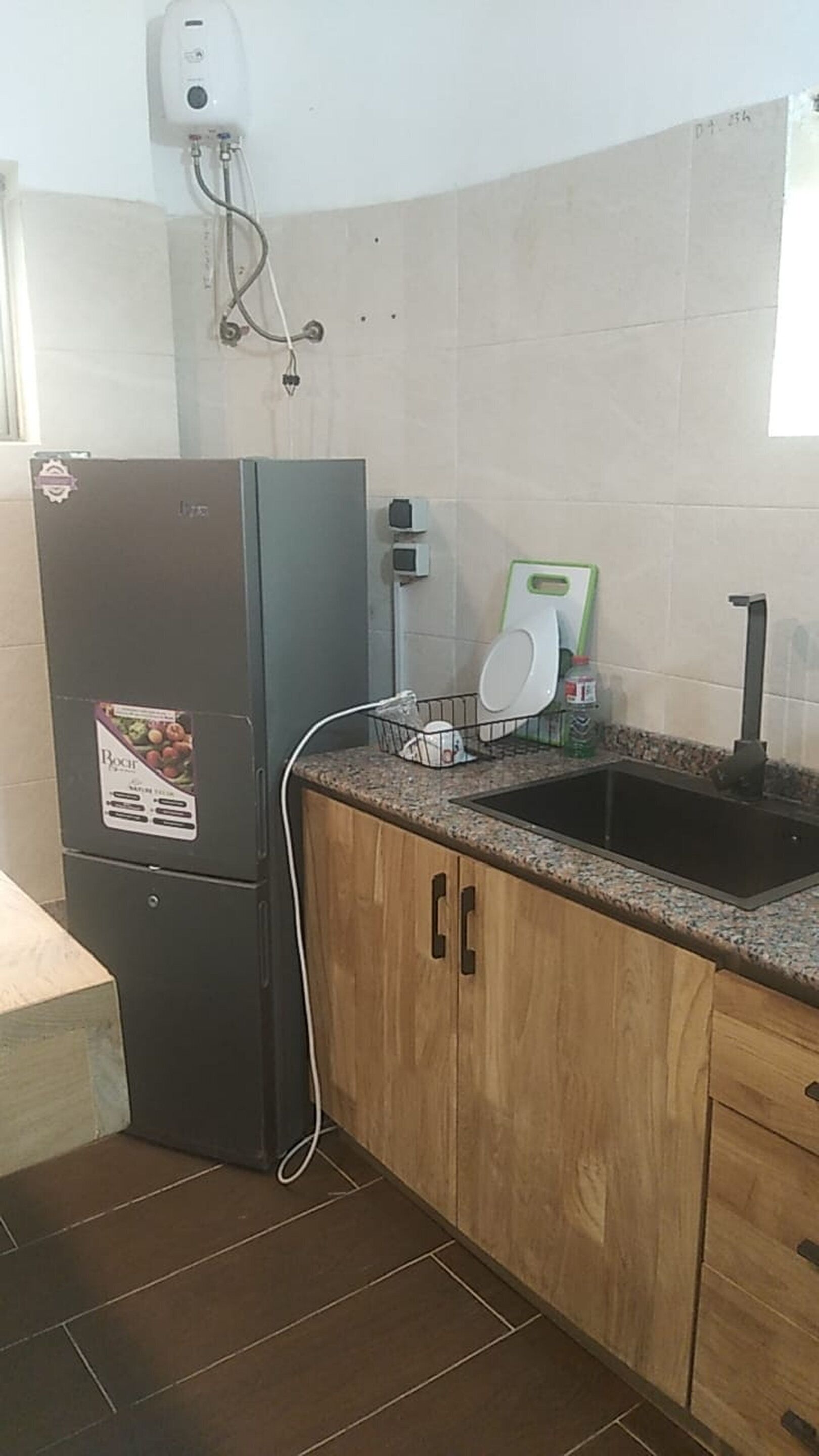 A compact kitchen with a refrigerator, a sink, and a countertop.