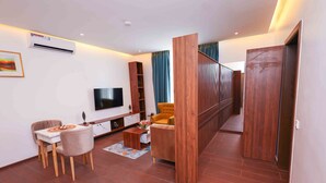 Una sala de estar moderna con un televisor de pantalla plana, muebles de madera y un comedor.
