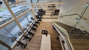 Un gimnasio con bicicletas estáticas y una escalera.