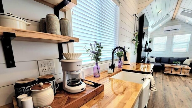 A modern kitchen with wooden countertops, a coffee maker, and a sink. There are shelves above the counter holding jars and a plant. - Private Hot Tub + Rooftop Deck • Near Zion National Park (Apple Valley)