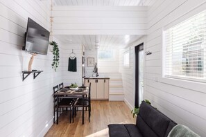 Un espace de vie compact comprenant un coin repas, une kitchenette et un canapé.