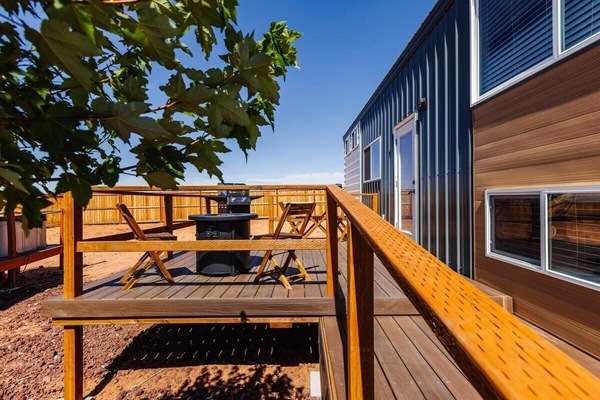 Relax on the spacious outdoor deck featuring a BBQ grill, a cozy fire pit, and a table with chairs for outdoor dining. Perfect for gatherings, this inviting space offers a great spot to cook, dine, and unwind while enjoying the fresh air.