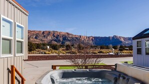 Un jacuzzi en un patio trasero con vista a la montaña.