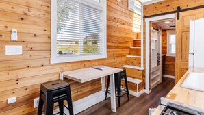 A wooden interior with a dining area, a window with blinds, and a kitchen area. - Pet-Friendly Family Escape • Near Zion (Apple Valley)