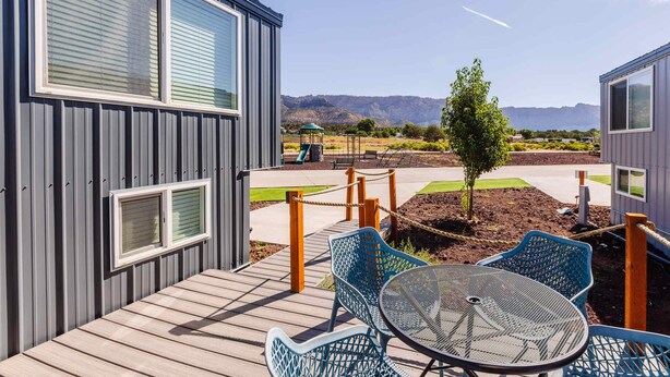 Terraza con mobiliario exterior y vista a un paisaje montañoso.