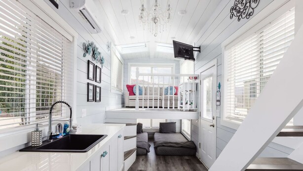 A compact, modern room with a kitchenette, a bunk bed, and a staircase. - Hot Tub Under Desert Sky • Zion Tiny Home Getaway (Apple Valley)