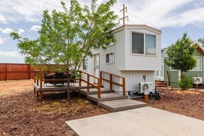 A small, single-story house with a deck and a staircase leading to the front door. - Pet-Friendly Zion Group Getaway (Apple Valley)