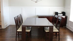 A dining area with a rectangular table, six chairs, a chandelier, and a small side table with speakers. - 2027 Augusta Masters Week Luxury Rental, 7 Miles from Augusta National Golf Club (Martinez)
