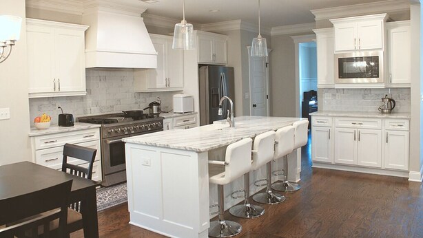 A modern kitchen with white cabinetry, a central island with bar stools, stainless steel appliances, and pendant lighting. - 2027 Augusta Masters Week Luxury Rental, 7 Miles from Augusta National Golf Club (Martinez)
