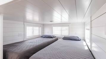 A bedroom with two beds, white walls, and a sloped ceiling.