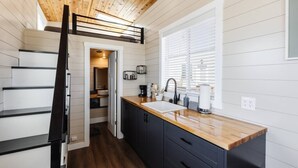 A modern kitchen with a wooden ceiling, white walls, and a wooden countertop. - Zion Adventure • Private Hot Tub + Starry Nights (Apple Valley)