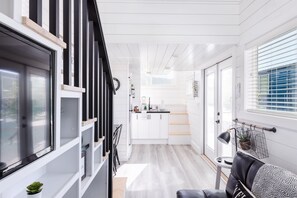 Une cuisine moderne avec des armoires blanches, un comptoir noir et un luminaire suspendu.