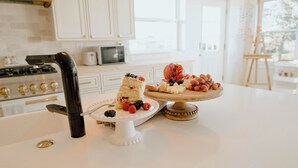 A kitchen counter with a cake and fruit display.